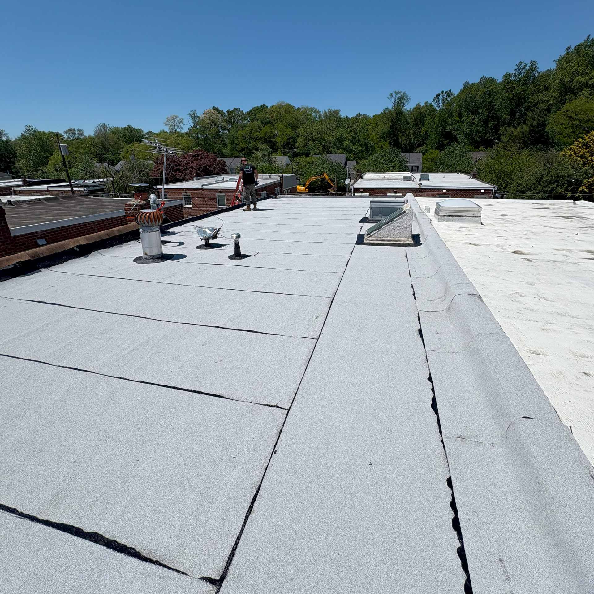 Worker from Doyle Roofing Company LLC on flat roof