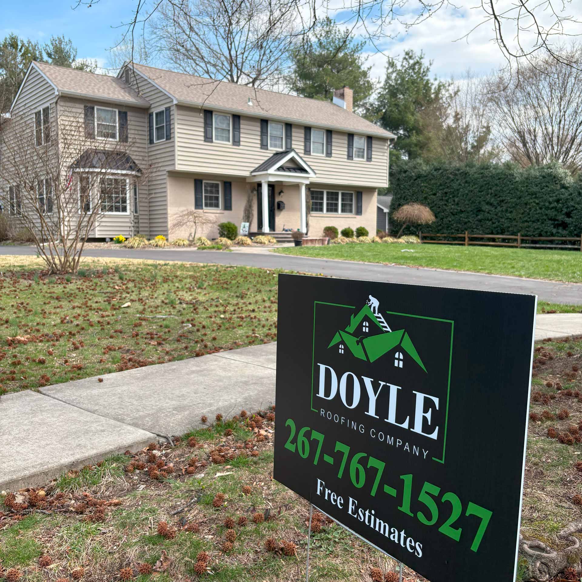 House with new shingle roof. There is a sign for Doyle Roofing Company LLC in the front yard