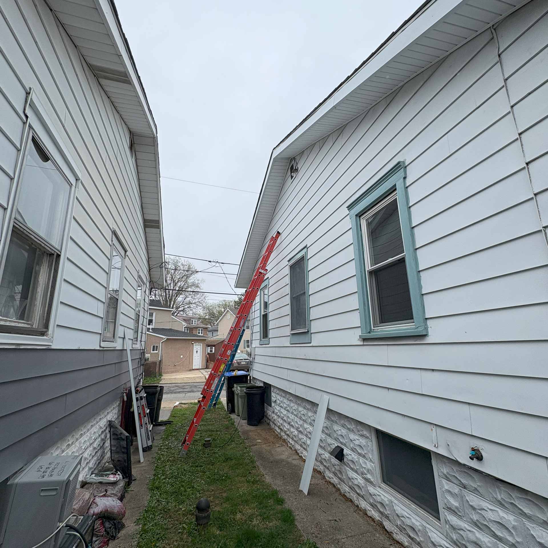 Ladder propped up on side of house for new gutter installation