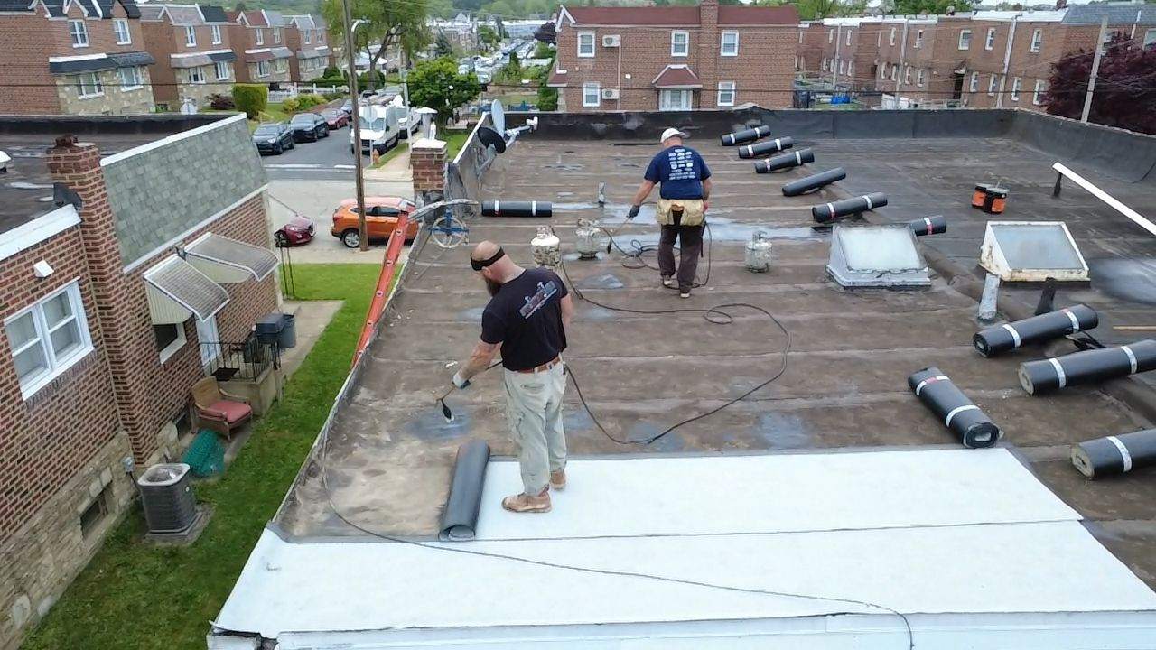 roofers from Doyle Roofing Company LLC at work on flat roof